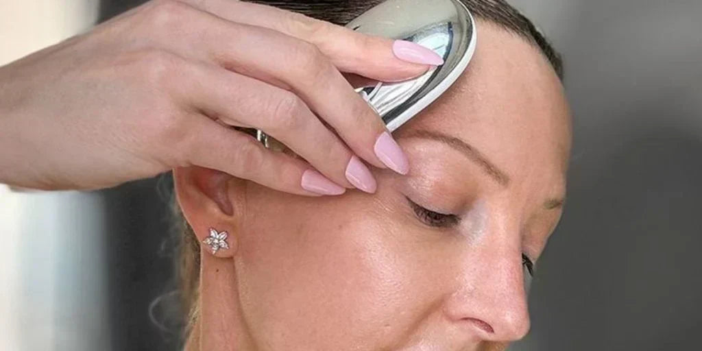 Close-up of a woman gliding ZIIP HALO across her forehead, eyes closed.