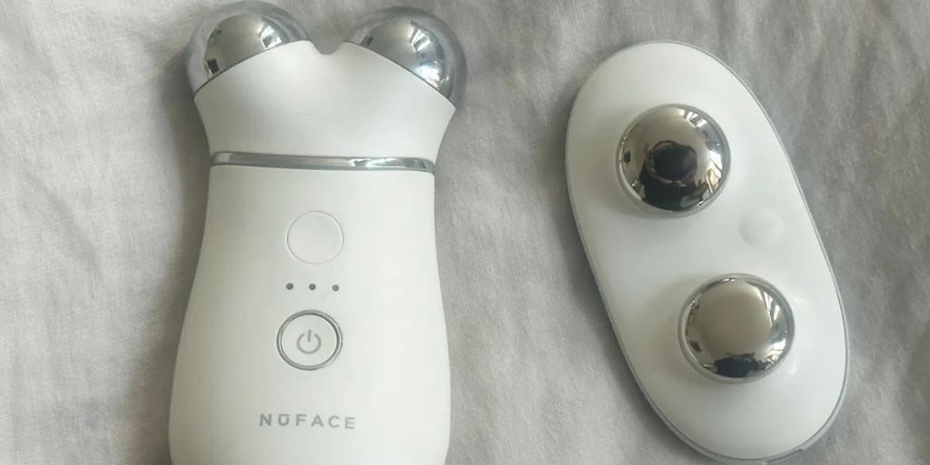 A NuFace device next to ZIIP HALO on a grey fabric surface.